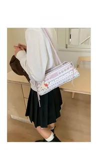 Vue détaillée du sac porté épaule rose avec motifs floraux et pendentif lapin beige