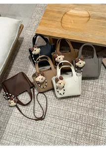 Detailed display of six leather bucket bags in different colors on a soft rug