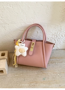 Borsa a secchiello rosa in pelle venata con chiusura dorata e ciondolo a forma di orso