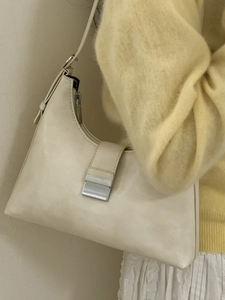 French retro creamy white shoulder bag with silver buckle worn with a casual outfit