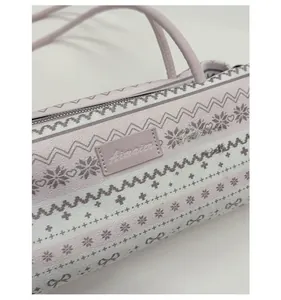 Gros plan sur un sac cylindrique lilas avec motifs géométriques nordiques et zip