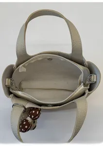 Detailed interior view of beige leather bucket bag showing three organized compartments