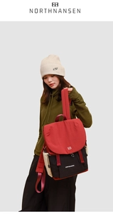 Detail of color-block backpack showing red, black, and beige panels with brand logo