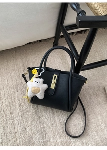 Primo piano della borsa retrò in pelle nera con chiusura dorata e ciondolo a stella