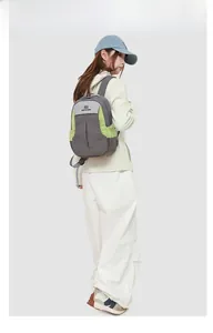 Sac à dos d'extérieur bicolore porté par un mannequin dans une tenue de sport épurée