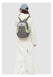 Détail du sac à dos de voyage contrasté avec empiècements gris et verts portés au dos