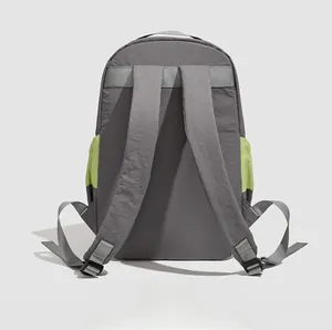 Vue arrière du sac à dos de voyage gris avec poches latérales vert fluo et bretelles rembourrées