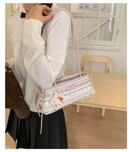 Détail du sac vintage rose avec imprimés flocons et breloque lapin blanc mignon