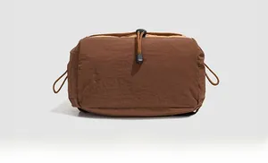 Detailed view of the brown nylon backpack bottom with textured fabric and drawstring buckle