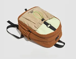 Detail of color-block backpack showing ripstop nylon texture and green drawstring pockets