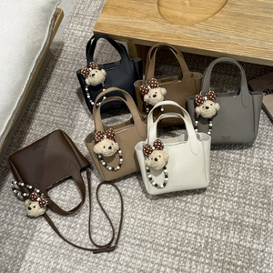 Five assorted colors of leather bucket bags featuring cute teddy bear charms and straps