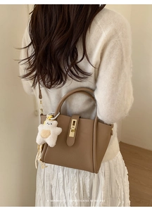 Borsa a mano in pelle marrone con chiusura dorata e dettaglio ciondolo orsetto bianco