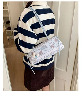 Détail du sac bandoulière bleu clair avec imprimés poney et pendentif lapin en peluche