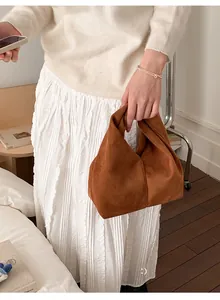 Detailed view of a brown suede hobo bag with minimalist knotted handle design