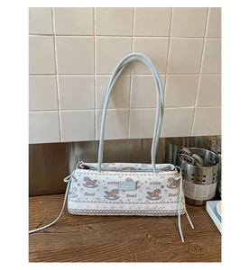 Détail du sac crème en cuir avec motifs mignons de cheval de bois et fraises