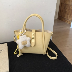 Dettaglio della borsa gialla in pelle litchi con fibbia d'oro e charm a stella