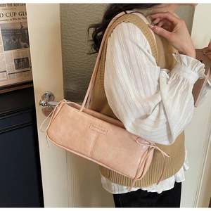 Close-up of a vintage apricot pink underarm bag with rectangular logo nameplate