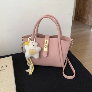 Borsa a secchiello rosa in pelle con fibbia dorata e ciondolo orsetto bianco