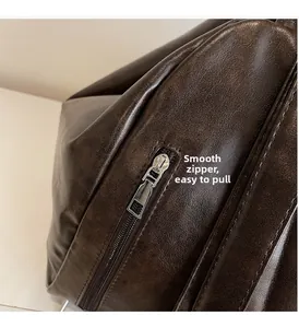 Detailed macro view of the smooth silver metal zipper on a dark brown leather tote bag
