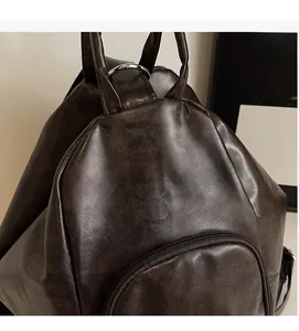 Detail of vintage brown leather backpack with distressed texture and front zipper pocket