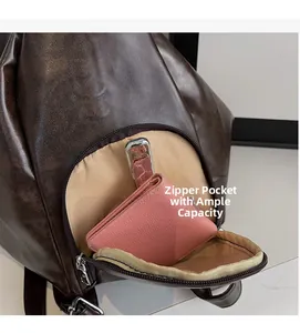 Detail of dark brown leather tote showing spacious front zipper pocket and lining
