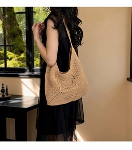 Detailed macro view of handmade crochet shoulder bag with hollow floral pattern and cotton weave