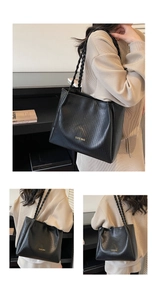 Détail du sac cabas noir à texture tressée avec anses en corde et inscription dorée