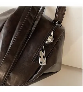 Detail of side zipper on dark brown vintage tote bag with high-quality faux leather texture