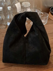 Minimalist black suede cloud bag with unique knot handle and spacious interior