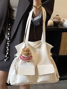 White faux leather tote bag with large front pockets and a cute teddy bear charm