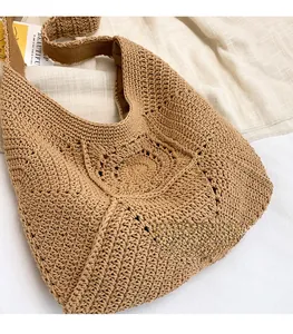Detailed macro view of the hollow flower crochet texture on a brown cotton woven beach bag