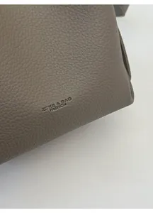 Close-up of taupe litchi grain leather texture with ZSKE & BAG FASHION logo engraving