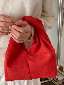 Minimalist red suede cloud bag with twisted handle and trendy ruched design