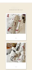 Close-up of white quilted backpack with polka dots and a plush rabbit pendant detail