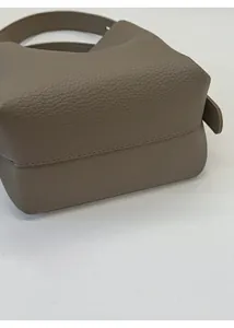 Detailed bottom view of the textured leather bucket bag showing the thick reinforced base