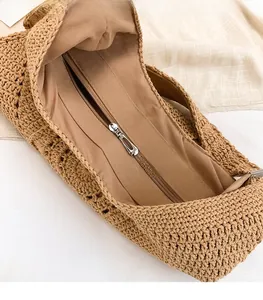 Close-up of woven beach bag showing internal fabric lining and silver metal zipper closure