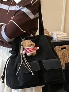 Black tote bag in matte suede with front flap pockets and cute teddy bear charm