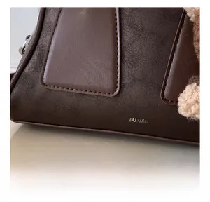 Nahaufnahme der braunen Ledertasche mit hochwertigen Nähten und weichem Anhänger