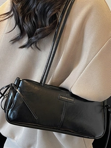 Minimalist black glossy leather underarm bag with drawstring and shoulder strap for women