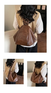 Detail view of brown vintage PU leather triangular backpack showing texture and front pocket