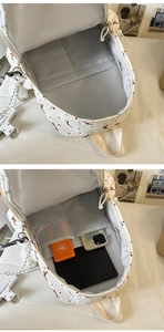 Spacious main compartment of cream backpack showing interior pockets and large storage capacity