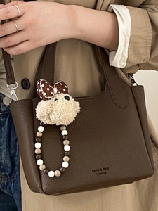 Vintage dark brown leather shoulder bag with plush dog charm and beaded strap detail