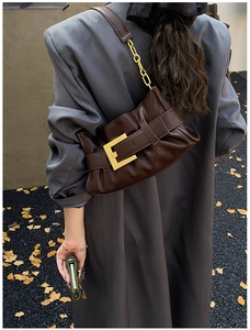 Close-up of brown faux leather shoulder bag with vintage gold buckle and chain strap