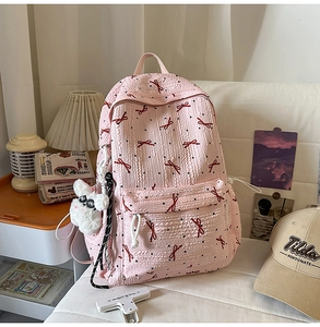 Detailed view of pink backpack featuring 3D seersucker fabric and red bow patterns