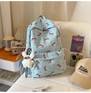 Detail of light blue backpack featuring wave texture, bow patterns and rabbit charm