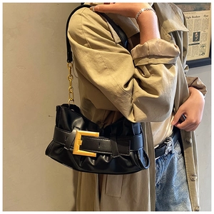 Close-up of black pleated underarm bag with gold buckle and chain strap for women