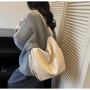 Detailed side view of large beige pleated tote bag with stylish zipper on soft PU leather
