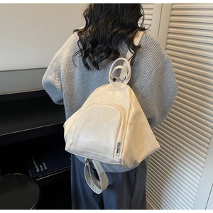 Detail view of the cream white PU leather backpack with a minimalist pleated design
