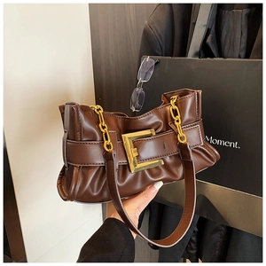 Detail of vintage chocolate brown pleated shoulder bag with large gold square buckle