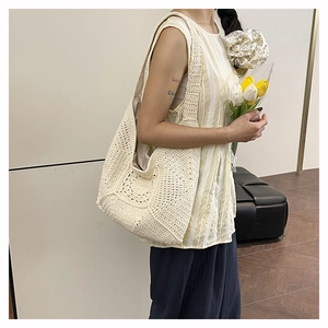 Detail of hollow floral crochet knit pattern on beige cotton woven shoulder beach bag